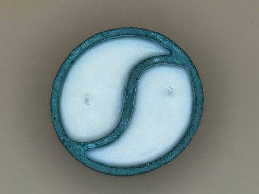 Top view Cylindrical concrete candle holder with a Yin-Yang design on a beige background