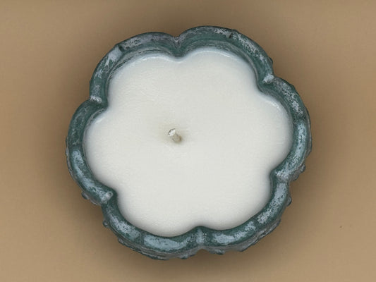 Top view Concrete candle holder with a candle inside on a beige background