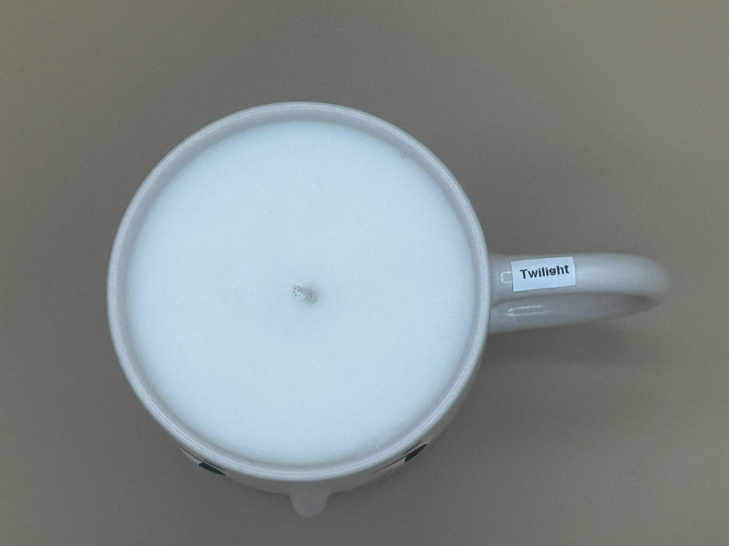 White mug Candle with a handle on a brown background