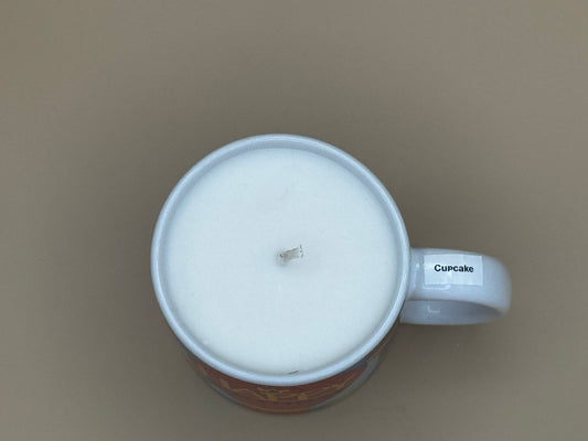 Top view Colorful mug with 'Happy Birthday' text and a candle inside on a beige background