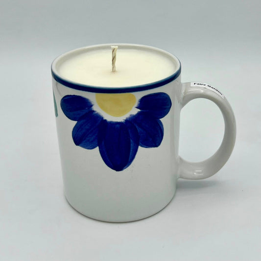 Candle in a mug with a blue flower design on a white background