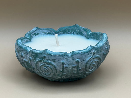 Concrete candle holder with a candle inside on a beige background