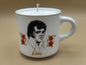 Candle in a mug with a portrait of Elvis Presley and flowers on a beige background
