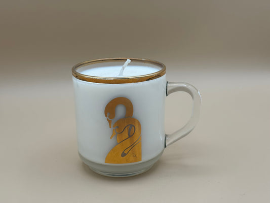 Candle in a glass mug with a logo on a plain background