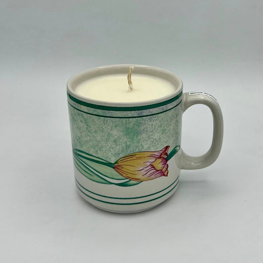 Ceramic mug with a candle inside on a gray background