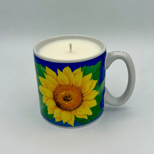 Candle in a mug with sunflower design on a white background